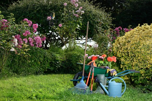 Gardener with gloves and tools beginning maintenance in Thamesmead garden